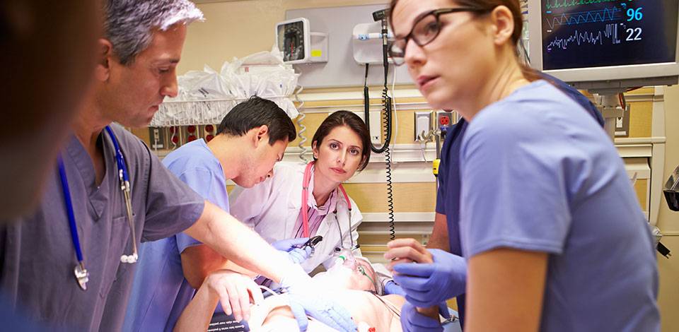 Specialist doctors and nurses around a patient in theatre