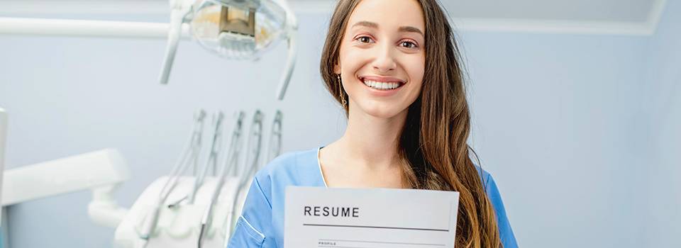 Young dentist assistant or student holding resume for a job at the dental office